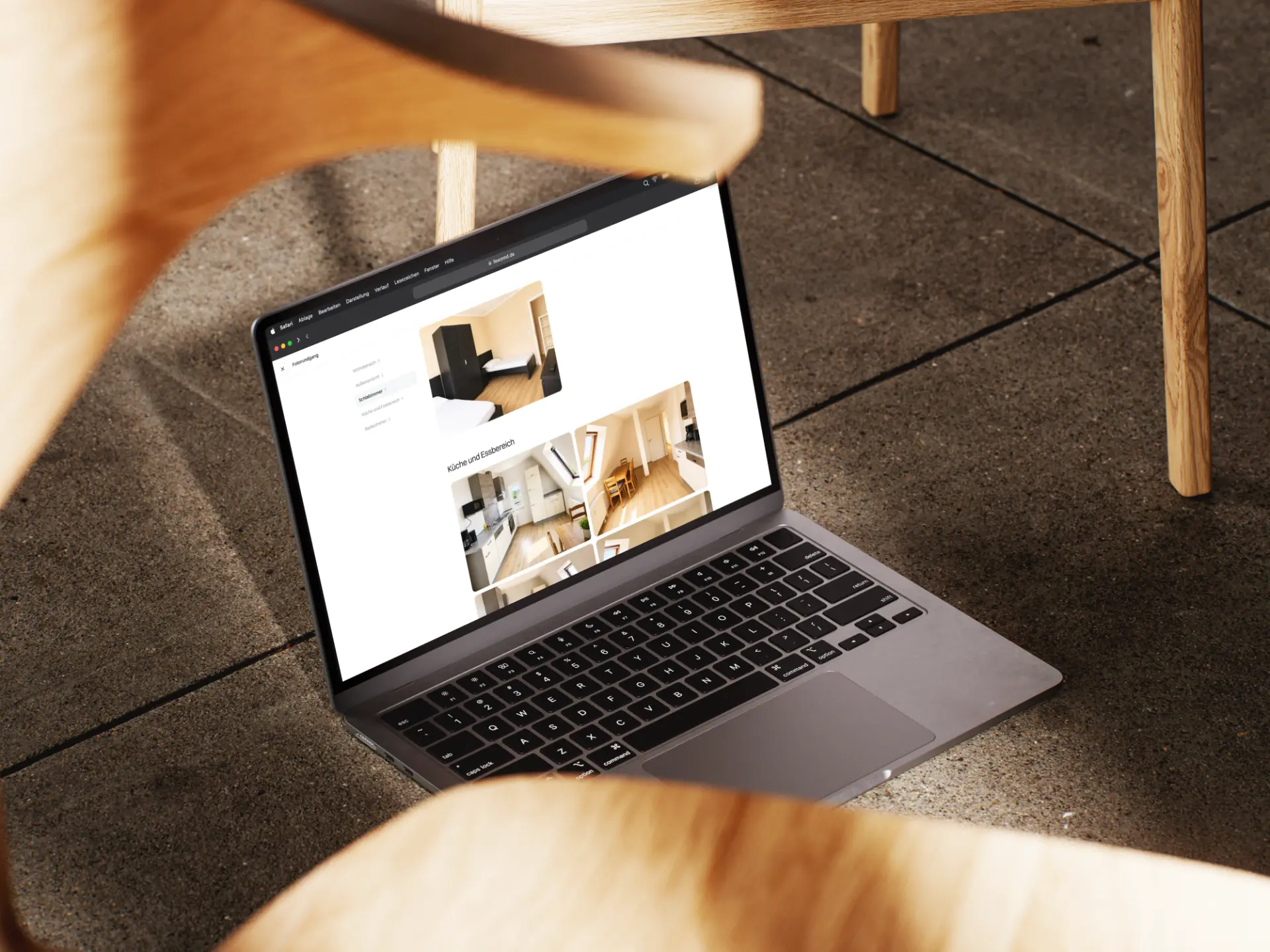 Wohnungsseite von Fewo MD mit Fotos von Küche und Esstisch auf einem Laptop auf einem Holzstuhl